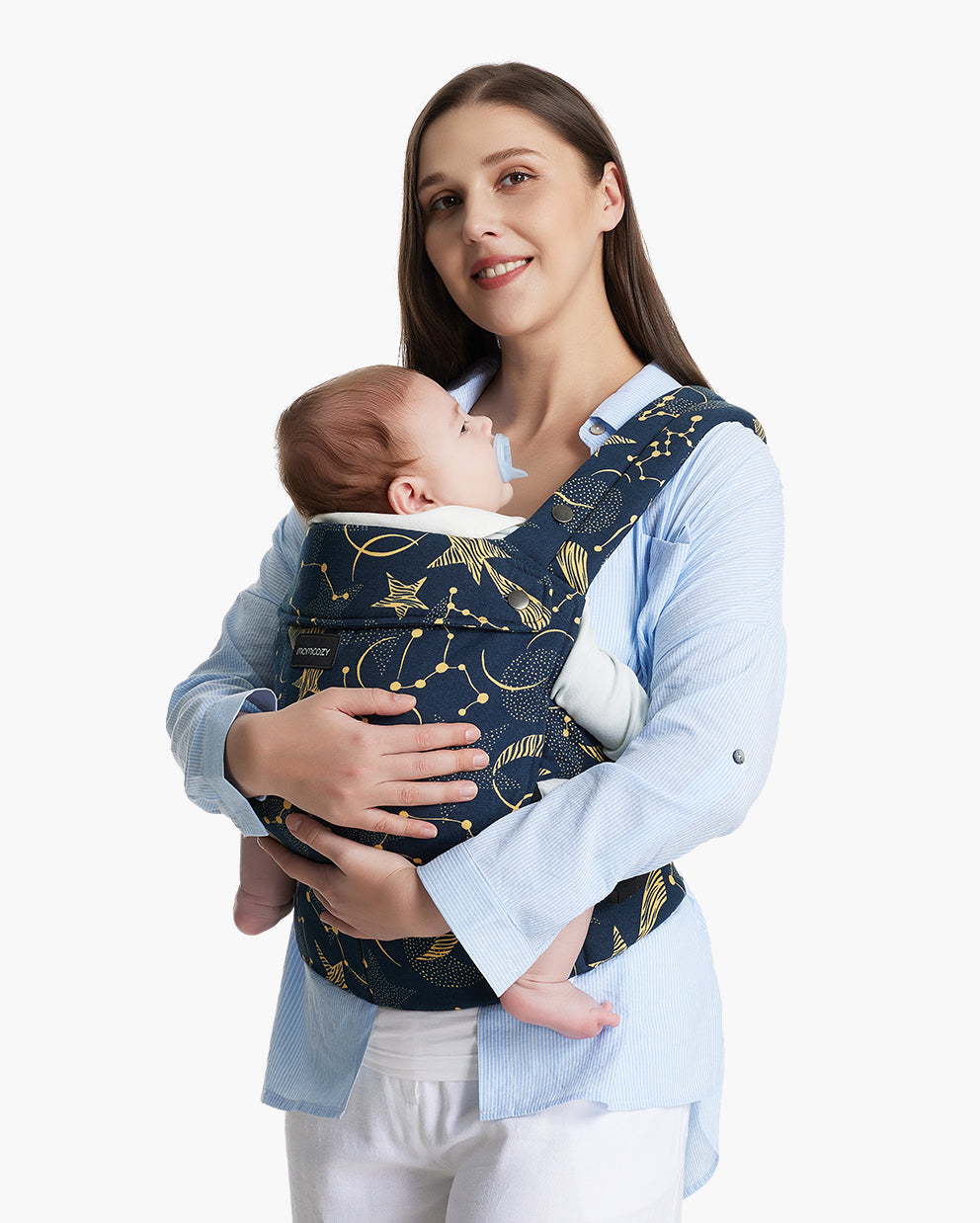Woman in blue shirt holding baby in navy Momcozy ergonomic carrier with star pattern.
