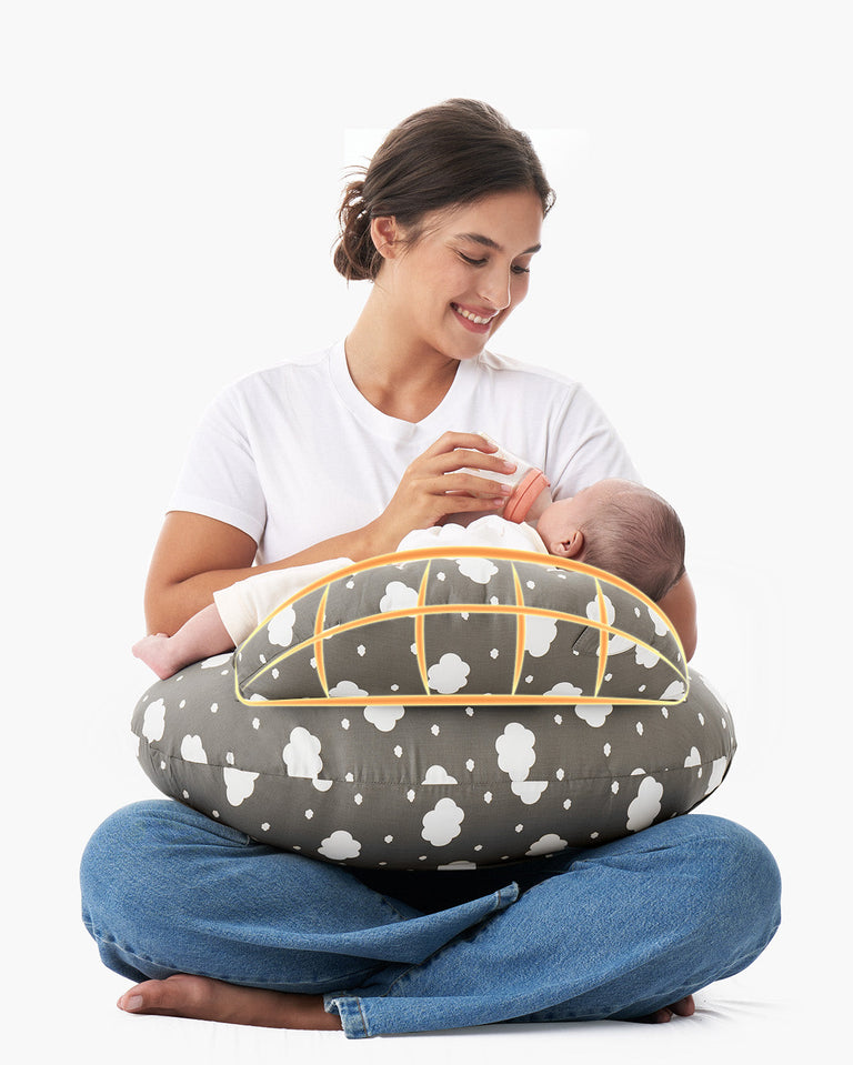 Translation missing: es.Woman bottle-feeding baby on multifunctional adjustable nursing pillow with cloud pattern