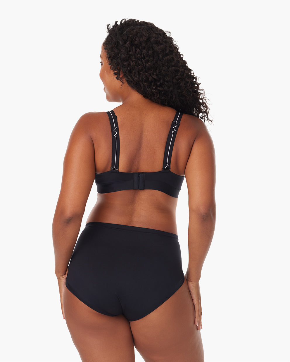 Back view of a nursing mother wearing a black CozyFitClasp bra showcasing adjustable straps.