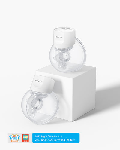 Momcozy S12 Pro Wearable Breast Pumps with transparent milk collectors and award badges displayed on a pedestal.